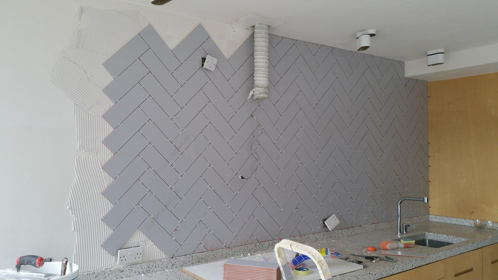 Herringbone wall tiling installation