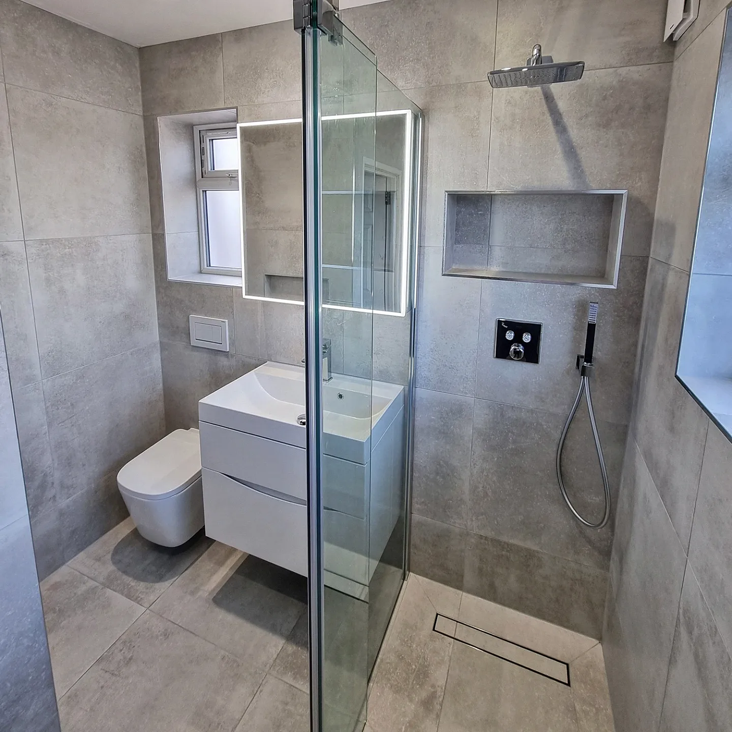 Wet room large-format tiling with niche and linear drain, Crouch End
